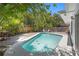 Private backyard pool surrounded by lush landscaping and a brick patio at 628 Bosphorous Ave, Tampa, FL 33606