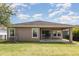 Backyard with a covered patio, a grassy lawn, and a black metal fence at 6524 Park Strand Dr, Apollo Beach, FL 33572