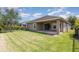 A spacious backyard features lush green grass and a covered patio with sliding glass doors at 6524 Park Strand Dr, Apollo Beach, FL 33572