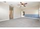 Large bedroom with neutral carpet, a ceiling fan, and access to en-suite bathroom at 6524 Park Strand Dr, Apollo Beach, FL 33572