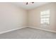 Empty bedroom with neutral gray carpet, a ceiling fan, and a window at 6524 Park Strand Dr, Apollo Beach, FL 33572