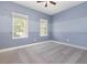 Bedroom with gray carpet, two-tone blue walls, a ceiling fan, and two windows at 6524 Park Strand Dr, Apollo Beach, FL 33572