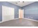 Bedroom features gray carpet, blue walls, a closet, and doorway at 6524 Park Strand Dr, Apollo Beach, FL 33572
