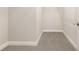 Empty walk-in closet with neutral gray carpet, white baseboards, and a hanging rod at 6524 Park Strand Dr, Apollo Beach, FL 33572