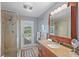 Bathroom featuring walk-in shower and a vanity with a granite countertop, and a door leading to the backyard at 6821 Date Palm S Ave, St Petersburg, FL 33707