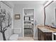 Bathroom showing granite vanity, tiled floor, toilet and door leading to a bedroom with a ceiling fan at 6821 Date Palm S Ave, St Petersburg, FL 33707