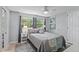 Serene bedroom featuring a comfortable bed, soft lighting, and windows offering a peaceful view of lush greenery at 6821 Date Palm S Ave, St Petersburg, FL 33707