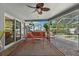 Screened-in patio with comfortable seating, a ceiling fan, and views of the pool and backyard at 6821 Date Palm S Ave, St Petersburg, FL 33707