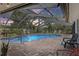 Screened-in pool area with a hot tub and various lounge chairs, surrounded by brick pavers and lush landscaping at 6821 Date Palm S Ave, St Petersburg, FL 33707