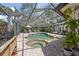 A luxurious screened pool with a spa, brick pavers, lounge furniture, and well-maintained landscaping at 6821 Date Palm S Ave, St Petersburg, FL 33707