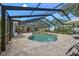 Screened-in pool area featuring brick pavers, a covered lanai, and inviting lounge furniture at 6821 Date Palm S Ave, St Petersburg, FL 33707