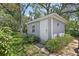 Exterior view of shed featuring a white door, window, gray paint, and surrounding greenery at 6821 Date Palm S Ave, St Petersburg, FL 33707