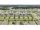 An aerial view of a neighborhood featuring well-maintained homes with manicured lawns and a glimpse of solar panels at 7323 Steer Blade Dr, Zephyrhills, FL 33541