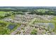 Expansive aerial view showcasing a community with lush green spaces, lakes, and multiple residences at 7323 Steer Blade Dr, Zephyrhills, FL 33541