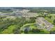 A scenic aerial shot featuring a community with interspersed ponds, flourishing greenery, and diverse homes at 7323 Steer Blade Dr, Zephyrhills, FL 33541