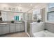 Elegant bathroom featuring double vanity, large mirror, and separate glass shower at 7323 Steer Blade Dr, Zephyrhills, FL 33541