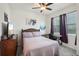 Bedroom with a ceiling fan, natural lighting, and purple curtains at 7323 Steer Blade Dr, Zephyrhills, FL 33541
