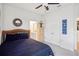Cozy bedroom featuring a woven headboard, ceiling fan, and ensuite bathroom access at 7323 Steer Blade Dr, Zephyrhills, FL 33541
