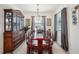 Dining room featuring an elegant chandelier, display cabinet, and large window at 7323 Steer Blade Dr, Zephyrhills, FL 33541