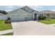 Beautifully landscaped front yard and long driveway leading to this single-story home at 7323 Steer Blade Dr, Zephyrhills, FL 33541