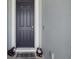 Front door entrance features a black door, dog statues, and a 'Gathering' welcome mat at 7323 Steer Blade Dr, Zephyrhills, FL 33541