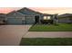 Charming single-story home featuring a well-manicured lawn, two-car garage, and stone accents on the facade at 7323 Steer Blade Dr, Zephyrhills, FL 33541