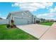 Beautiful single-story home featuring a spacious driveway and landscaped yard with stone accent columns at 7323 Steer Blade Dr, Zephyrhills, FL 33541
