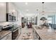 Modern kitchen with gray cabinets, granite countertops, stainless steel appliances, and island at 7323 Steer Blade Dr, Zephyrhills, FL 33541