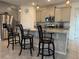 Modern kitchen with granite countertops, stainless steel appliances, and bar stool seating at 7323 Steer Blade Dr, Zephyrhills, FL 33541