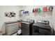 Functional laundry room with modern washer and dryer, granite countertop, and extra storage space at 7323 Steer Blade Dr, Zephyrhills, FL 33541
