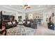 Open-concept living room connected to the kitchen with tile floors, plush seating, and recessed lighting at 7323 Steer Blade Dr, Zephyrhills, FL 33541