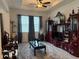 Living room with dark wood decor, a ceiling fan, carpet, and a large window overlooking the outside at 7323 Steer Blade Dr, Zephyrhills, FL 33541