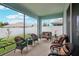 Covered, screened lanai with wicker seating and outdoor views at 7323 Steer Blade Dr, Zephyrhills, FL 33541