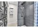 Sleek bathroom with grey tiles, a modern shower system, and a convenient laundry area, offering both style and functionality at 7530 85Th Ln, Seminole, FL 33777