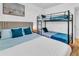Bedroom with a queen-sized bed, twin-sized bunk bed and bright blue accent pillows at 7530 85Th Ln, Seminole, FL 33777