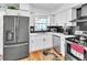 Well-lit kitchen featuring stainless steel appliances, white cabinets, and a black backsplash at 7530 85Th Ln, Seminole, FL 33777