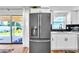 This lovely kitchen features a modern stainless steel refrigerator and sliding glass doors to the backyard at 7530 85Th Ln, Seminole, FL 33777