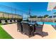 Outdoor dining area featuring a patio table with chairs, complemented by a lounge area and beautiful pool views at 7530 85Th Ln, Seminole, FL 33777