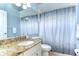 Neutral bathroom with granite sink, shower curtain, and neutral walls at 7824 Primula Ln, New Port Richey, FL 34654