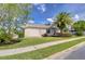 Side exterior view of a home showcasing its well-maintained lawn and landscaping at 7824 Primula Ln, New Port Richey, FL 34654