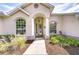 A charming front porch with white columns and arched windows, surrounded by landscaped flower beds at 7824 Primula Ln, New Port Richey, FL 34654