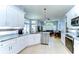 Bright kitchen with white cabinetry, granite countertops, and an open layout to the living space at 7824 Primula Ln, New Port Richey, FL 34654