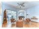 Living room with wood floors, a ceiling fan, and a sliding glass door leading to the pool area at 7824 Primula Ln, New Port Richey, FL 34654