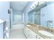 Bright bathroom with double sinks, granite countertop, a soaking tub with plantation shutters, and a separate shower at 7824 Primula Ln, New Port Richey, FL 34654