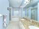 Bright bathroom with double sinks, granite countertop, a soaking tub with plantation shutters, and a separate shower at 7824 Primula Ln, New Port Richey, FL 34654