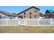 Backyard with a playset, white picket fence, and view of the house at 8103 Tar Hollow Dr, Gibsonton, FL 33534