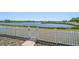 Scenic backyard with a white picket fence overlooking a serene lake, offering privacy and peaceful views at 8103 Tar Hollow Dr, Gibsonton, FL 33534