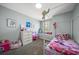 Charming bedroom with a white metal canopy bed, complemented by a whimsical collection of toys and colorful decor at 8103 Tar Hollow Dr, Gibsonton, FL 33534