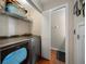 Convenient laundry room with modern appliances, ample storage shelves, and a stylish wood floor at 8103 Tar Hollow Dr, Gibsonton, FL 33534