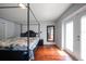 Comfortable main bedroom with hardwood floors, canopy bed, and natural light is an inviting retreat at 8103 Tar Hollow Dr, Gibsonton, FL 33534